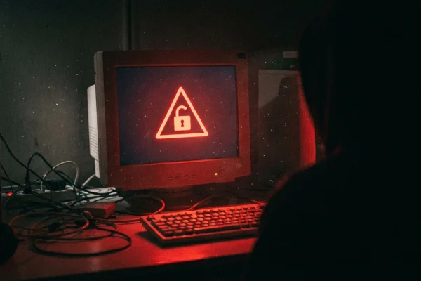 Ecrã de computador com símbolo de aviso vermelho e cadeado aberto